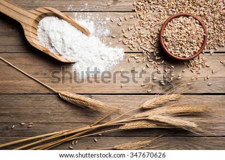 Ear grains, flour and wholegrains on wood table