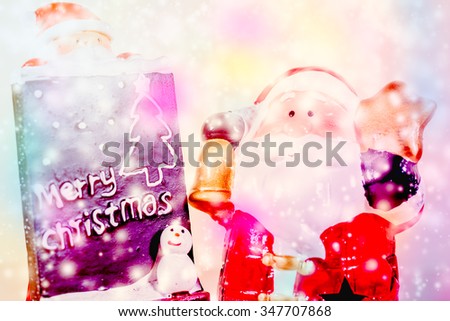 Santa Claus standing in the snow fake with a blackboard on colorful background