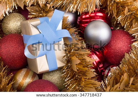 little gift and christmas balls in gold, red as background for copy space / gift and christmas balls