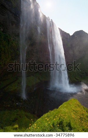 picture of beautiful Seljalandsfoss waterfall taken against sun Iceland