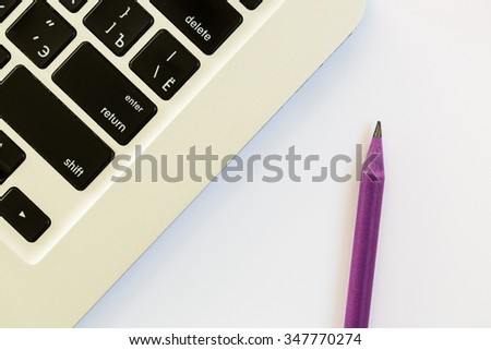 A laptop and a purple pencil isolated on white