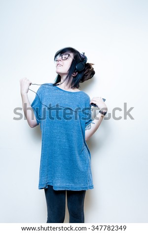 Pretty young teen woman with mobile phone listening music on white