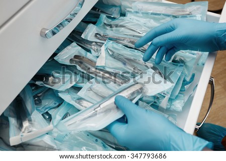 Medical laboratory technician holding a set of sterile disposable instruments Royalty-Free Stock Photo #347793686