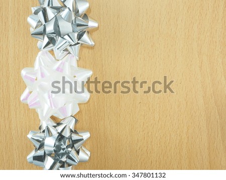 a wooden frame decorating with white-pearl and silver color bows.