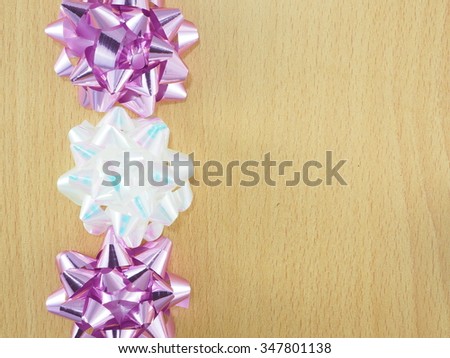 a wooden frame decorating with purple and white-pearl color bows.