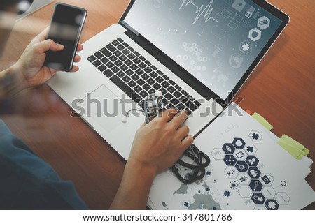 top view of Medicine doctor hand working with modern computer and smart phone on wooden desk as medical concept