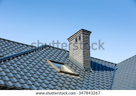 Roof of a detached house with a skylight and chimney against the sky Royalty-Free Stock Photo #347843267