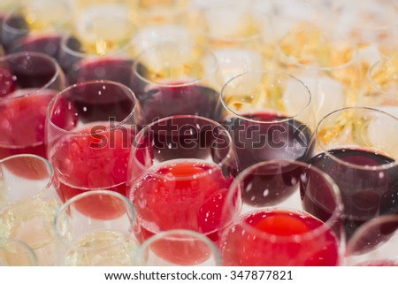 Beautiful row line of different colored alcohol cocktails with mint on a christmas party, martini, vodka with bubbles, wine and others on decorated catering bouquet table on open air event, picture 