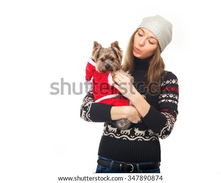 Young woman in a winter jacket is holding a dog dressed as Santa Claus. York Terrier dog breed. Beautiful girl and a dog on a white background. New year concept.
Whistle.
