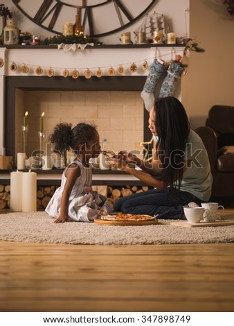 Mother and Daughter eating pizza at home