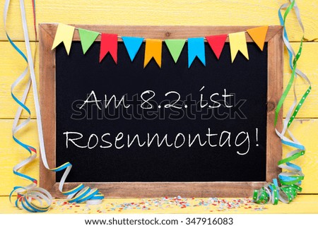 Chalkboard With German Text Rosenmontag Means Carnival. Party Decoration Like Streamer, Confetti And Bunting Flags. Yellow Wooden Background With Vintage, Retro Or Rustic Syle