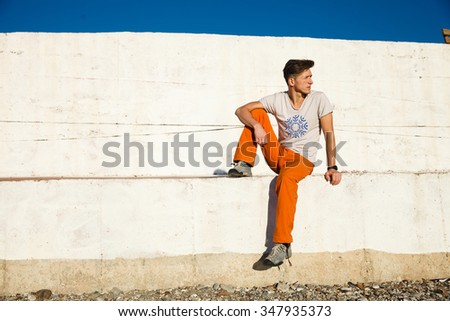 Young man getting rest and relax on the sidewalks over the sea, blue sky and palms
