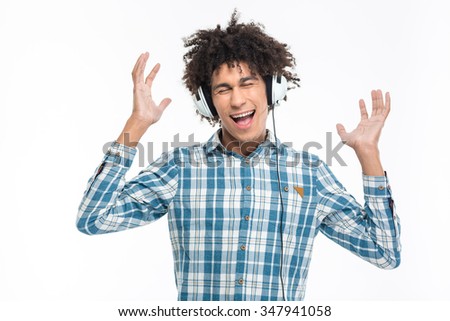 Portrait of a cheerful afro american man listening music in headphones isolated on a white background