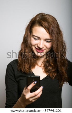 beautiful girl dials sms congratulations by phone, office manager concept shot isolated on gray background