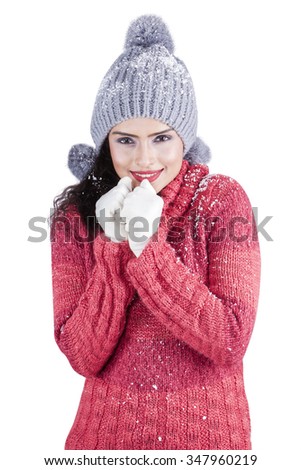 Image of beautiful indian woman wearing winter clothes and feeling cold, isolated on white background