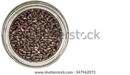 Black millet in mason jars over wooden background