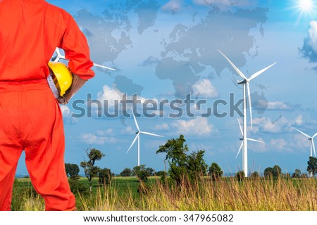 Asian engineers holding a yellow hardhat on Wind turbine power generator with world map, industrial concept, Elements of this image furnished by NASA