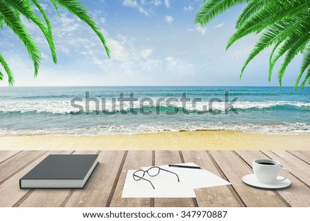 Diary, blank papers and cup of coffee on wooden bench at beach background
