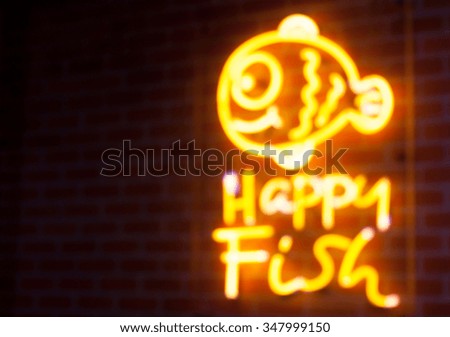 Blurry text fish neon light on wall