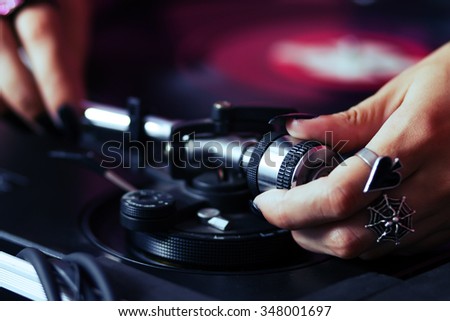 Dj girl playing music on vinyl. Female disc jockey adjusting turntables tone arm weights to play hip hop music on party. Curated collection of royalty free music images and photos for poster design