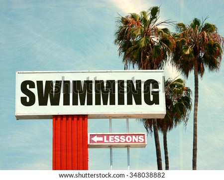 aged and worn vintage photo of swimming lessons sign with palm trees