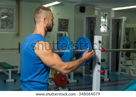 The athlete preparing for bench bar to the chest muscles in the gym. Preparing to heavy exercise. Professional training of the young athlete. Photos for sporting magazines, posters and websites.