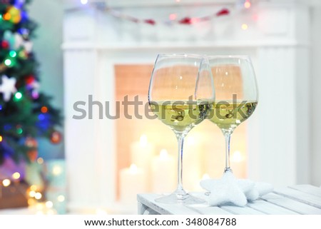 Wine glasses with Christmas decor on fireplace background