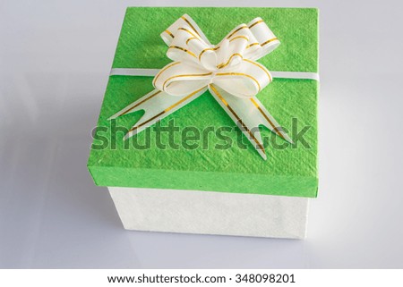 Gift box white with a green cap. Tied with a white ribbon isolate on white background.