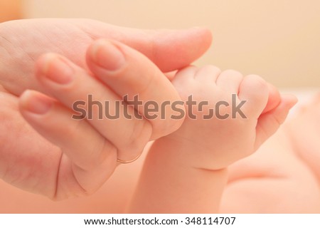 Baby holding mothers hand. Family and love concept.