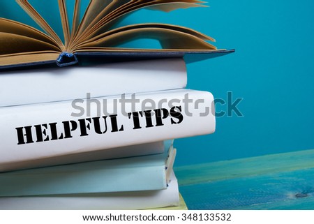 Open book, hardback books with Helpful Tips word on wooden table. Back to school. 
