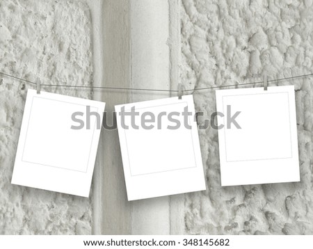 Three square frames hung by clothes pin on grey decorated concrete wall background 