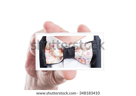 Hand holding card with bowtie picture as bow tie fashion concept