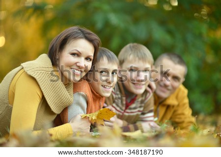 Happy smiling family relaxing in autumn park