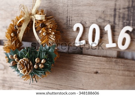 brown christmas wreath  with 2016 on the wooden background.