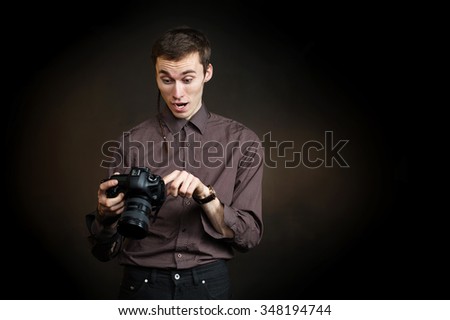Young male photographer looking surprised in professional camera. Photography Occupation, Photo school, studying