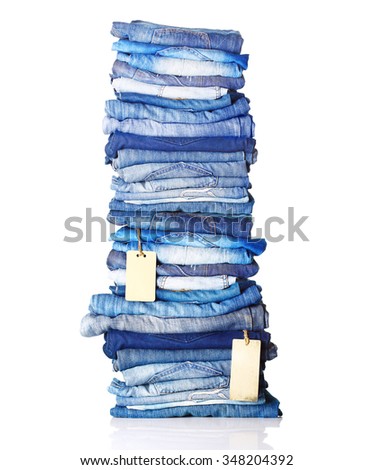 Pile of blue jeans with tags isolated on white.