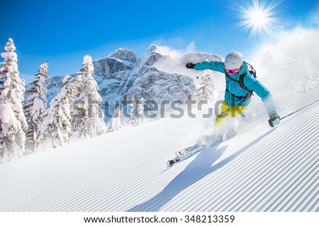 Skier skiing downhill in high mountains Royalty-Free Stock Photo #348213359