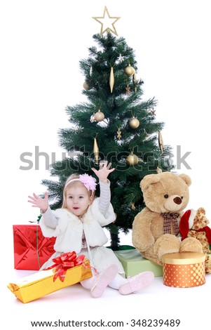 Happy little girl in fancy dress sitting around the Christmas tree-Isolated on white background