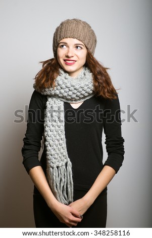 bright girl has a good idea, dressed in winter clothing, Christmas and New Year concept, studio photo isolated on a gray background