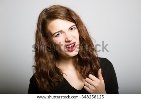 Bright girl angry points finger at you, life style concept studio photo isolated on a gray background