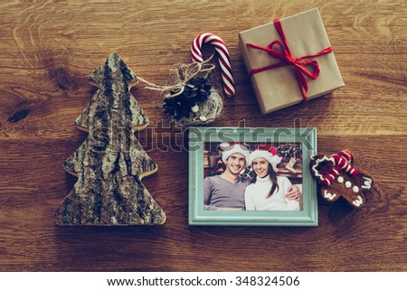 Christmas mood. Top view of Christmas decorations and photograph in picture frame laying on the rustic wooden grain 