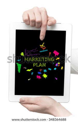 Young business woman pointing at Marketing Plan concept and uses tablet