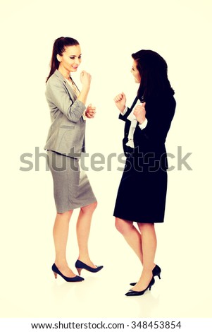 Two happy cheerful businesswomen making fists.