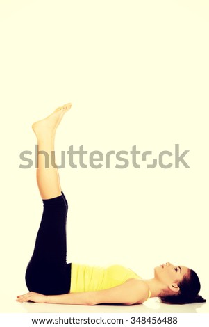 Fitness woman with her legs up practising yoga.