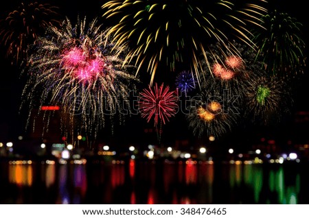 Colorful fireworks celebration and the city night light background.