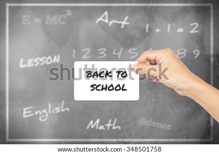 Hand holding card with word of "Back To School" chalkboard background