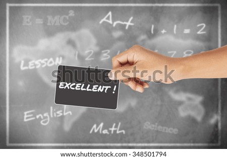Hand holding card with word of "Excellent" against chalkboard background