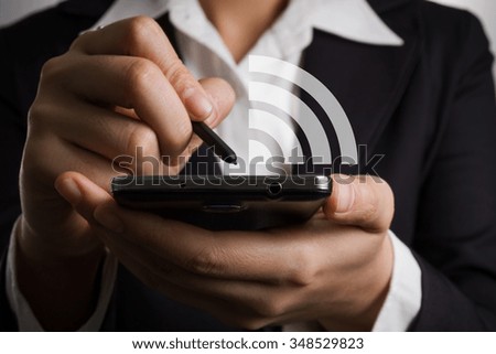 Close up businessman hand holding smart phone and pen with hand draw WiFi signal symbol.