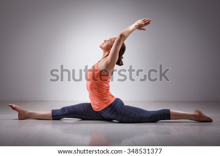 Sporty fit woman doing Hatha yoga asana Hanumanasana  (splits) - monkey pose Royalty-Free Stock Photo #348531377