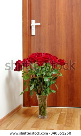 bouquet of red roses next to the door